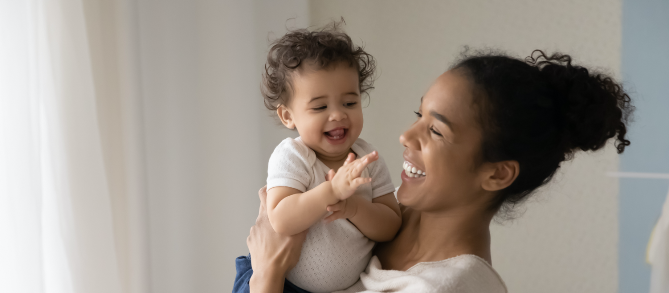 Adult holding baby and laughing 