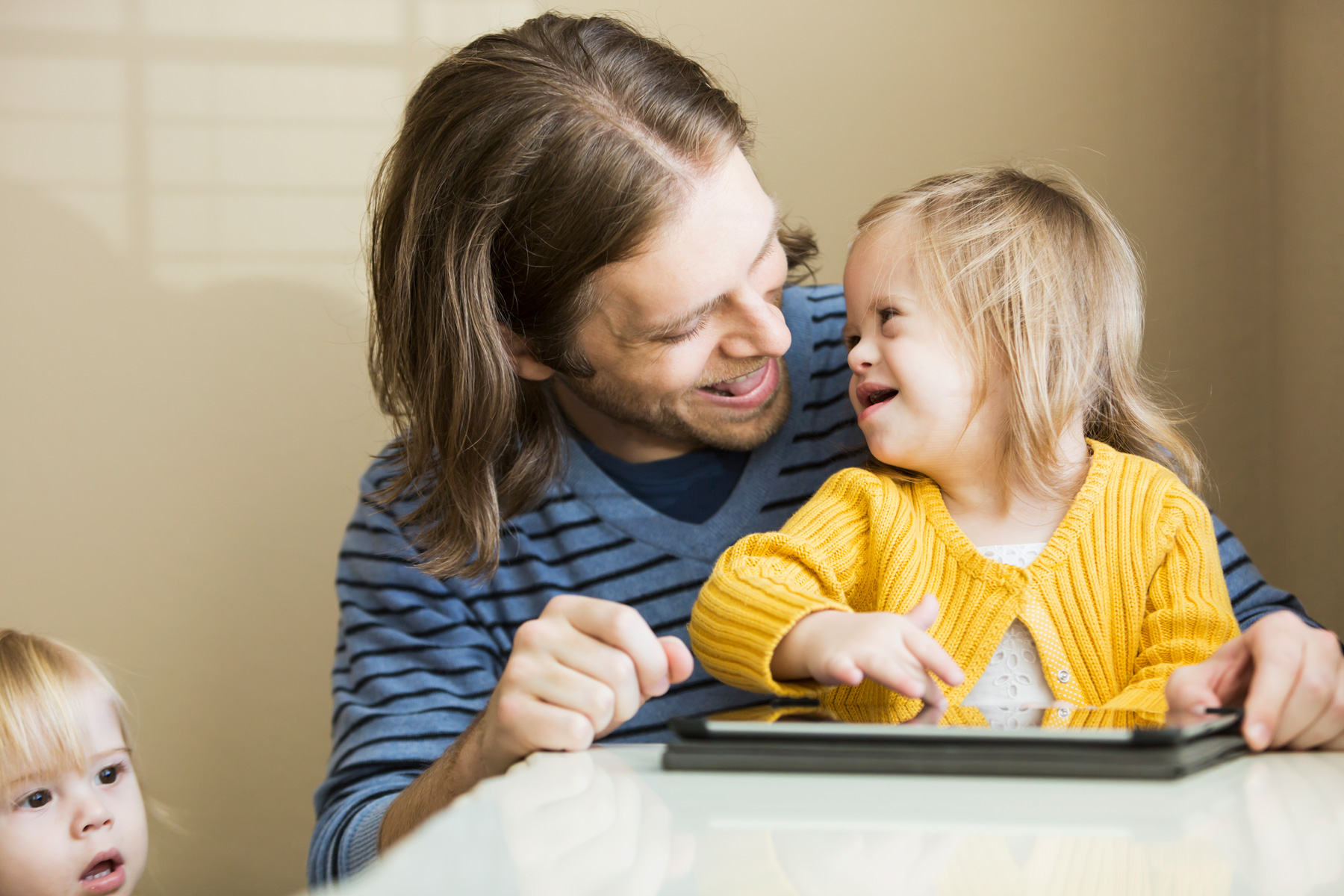 Father with a special needs daughter looking at ipad